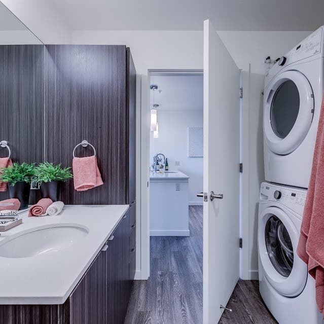 Osprey Apartments - bathroom with dark cabinets and white countertops