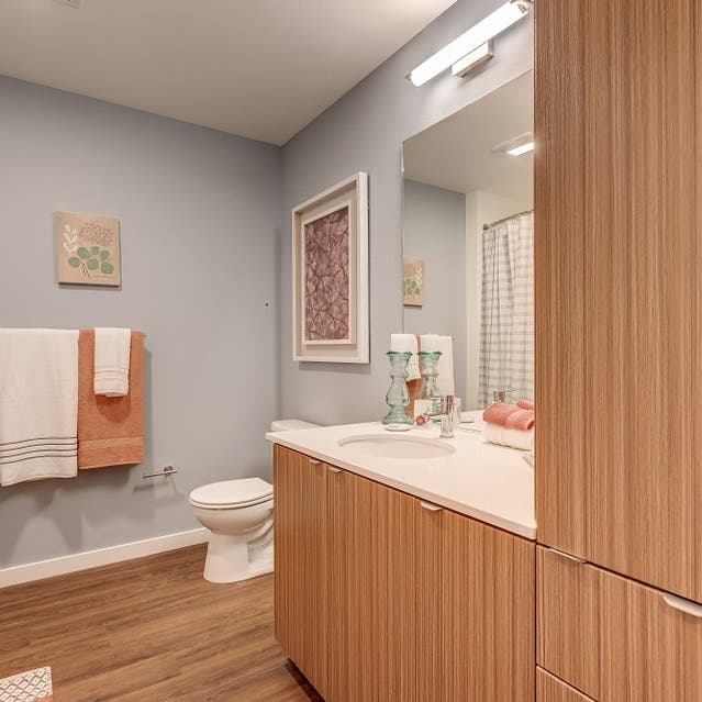 Osprey Apartments - bathroom with light cabinets and white countertops
