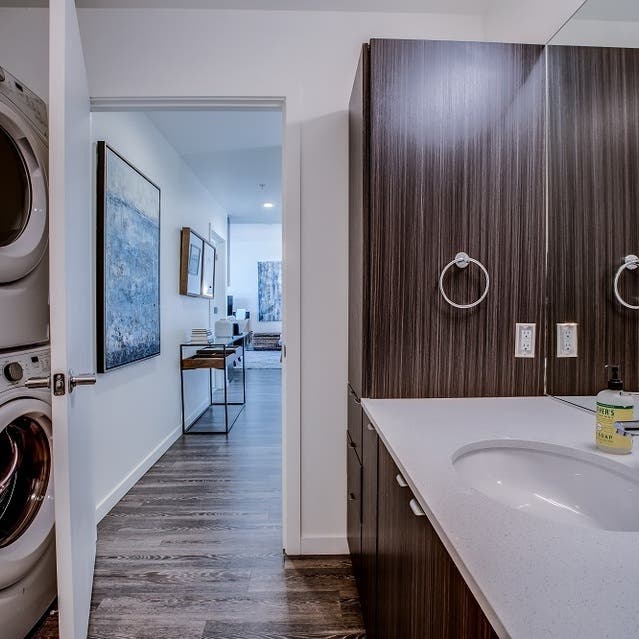 Osprey Apartments - bathroom with light cabinets and white countertops