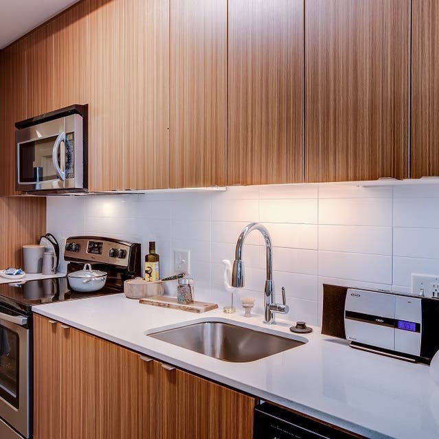 Osprey Apartments - kitchen with light cabinets, subway tile backsplash, white countertops, and stainless steel appliances